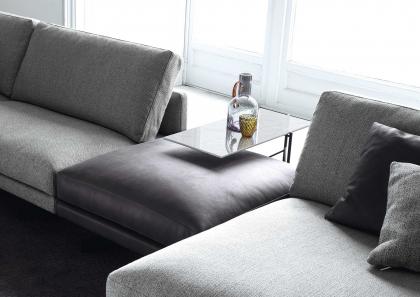Деталь элегантного кожаного пуфа и опорной плоскости в сочетании с диваном из ткани Dee Dee - BertO